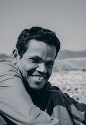 A confident man smiling while practicing mindfulness outdoors.
