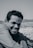 A smiling man in a relaxed setting, reflecting calmness.