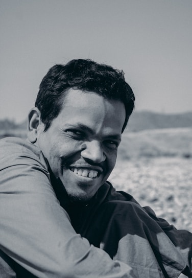 A warm, inviting portrait of the host smiling outdoors, surrounded by nature.