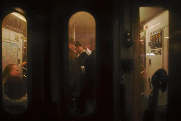 A lively group enjoying a Hazeblak Tours subway storytelling session with Boston landmarks visible through the train windows.