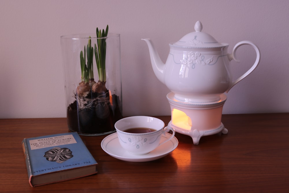 a table with a tea pot and a book on it