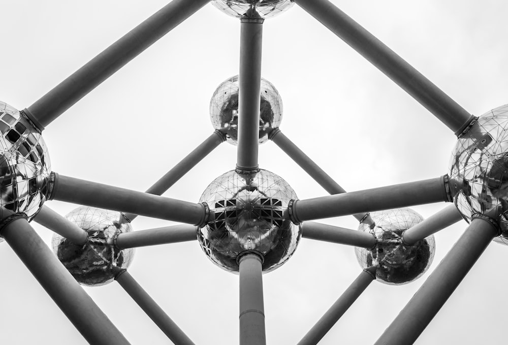 a black and white photo of a metal structure with mirrored balls