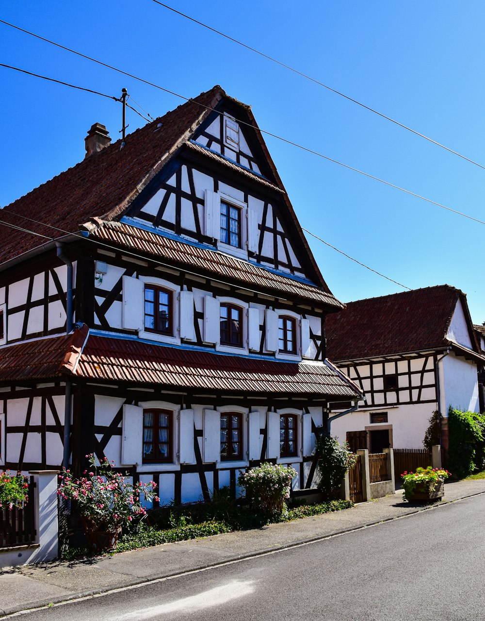 a white and black house with a brown roof