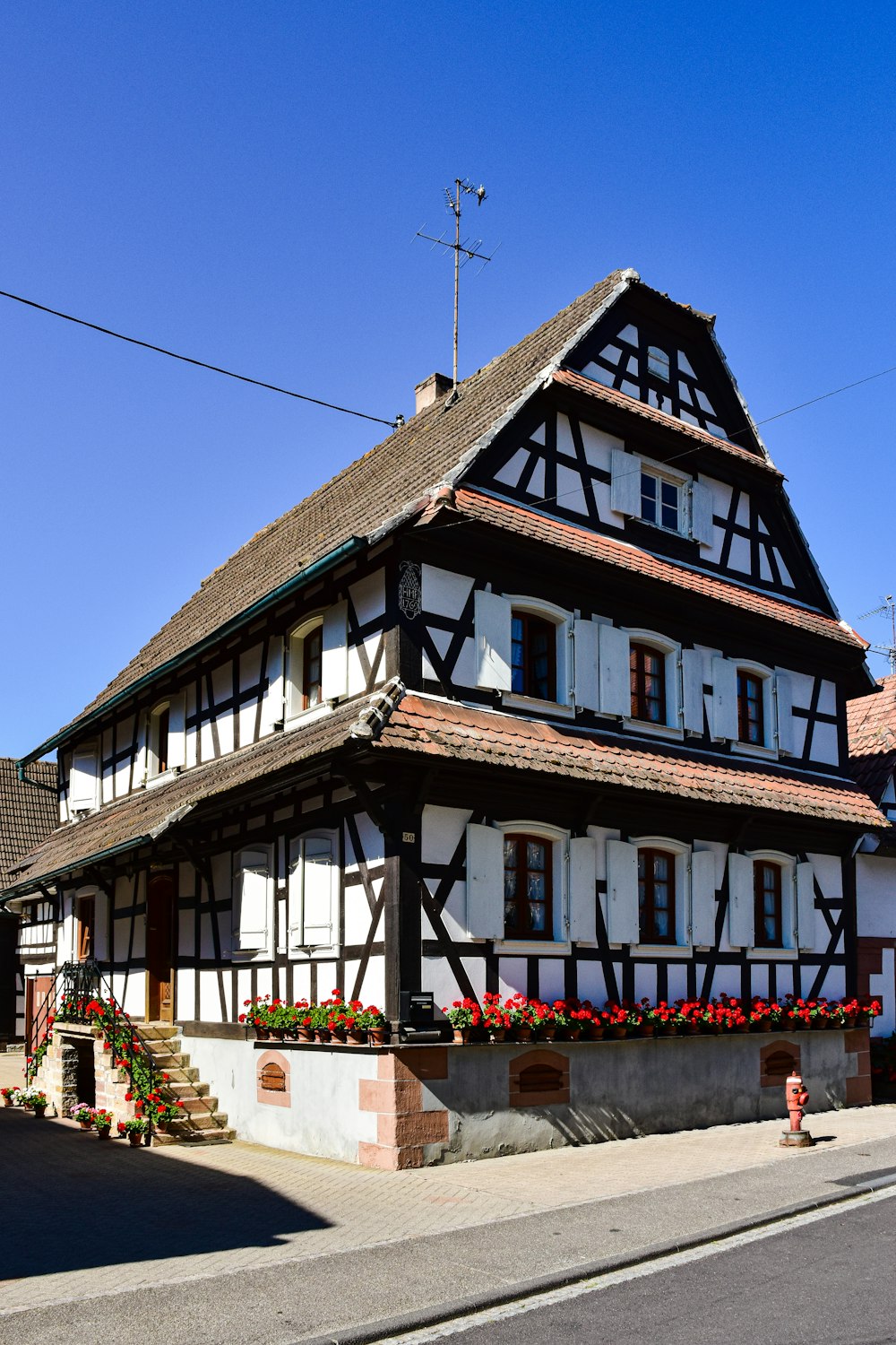 an old house with flowers growing on the side of it