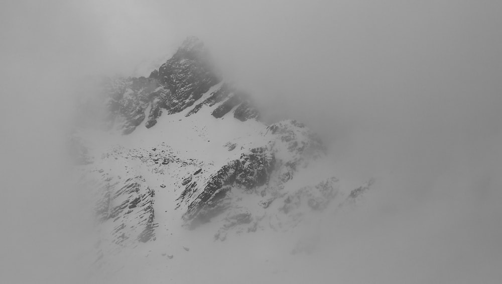 a very tall mountain covered in snow and clouds