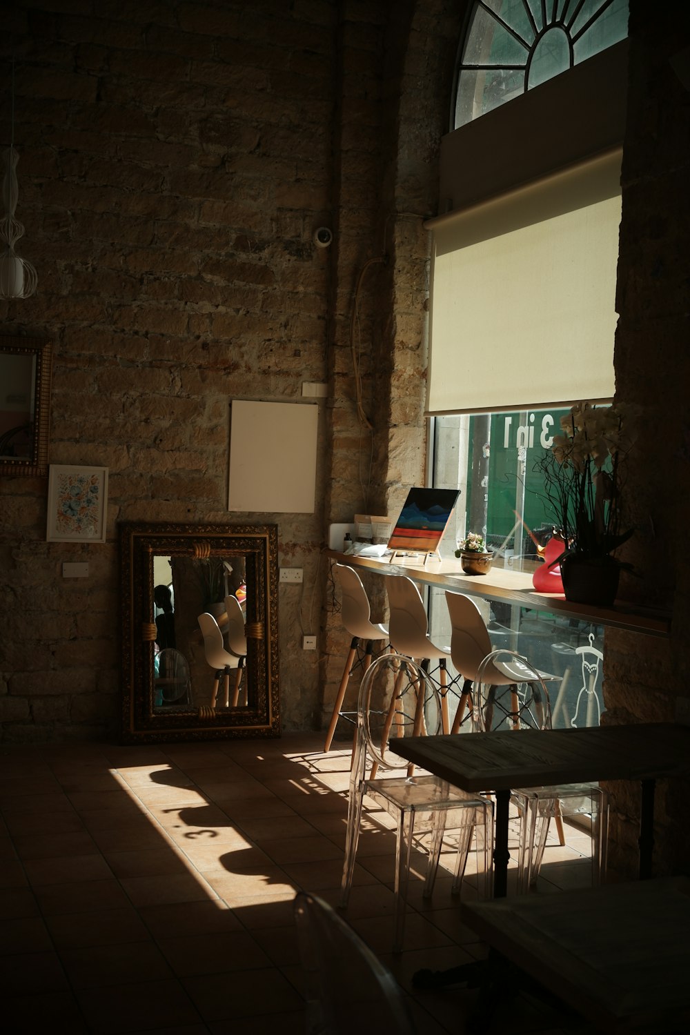 a room with a table, chairs and a mirror