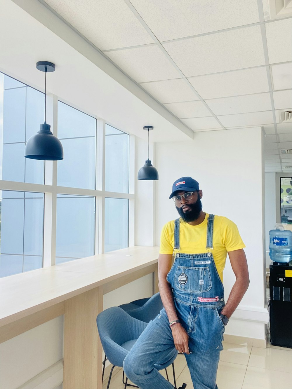 a man wearing overalls and a yellow shirt