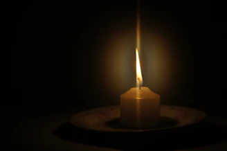 Flickering candlelight illuminating a textured ceramic plate with subtle shadows around.