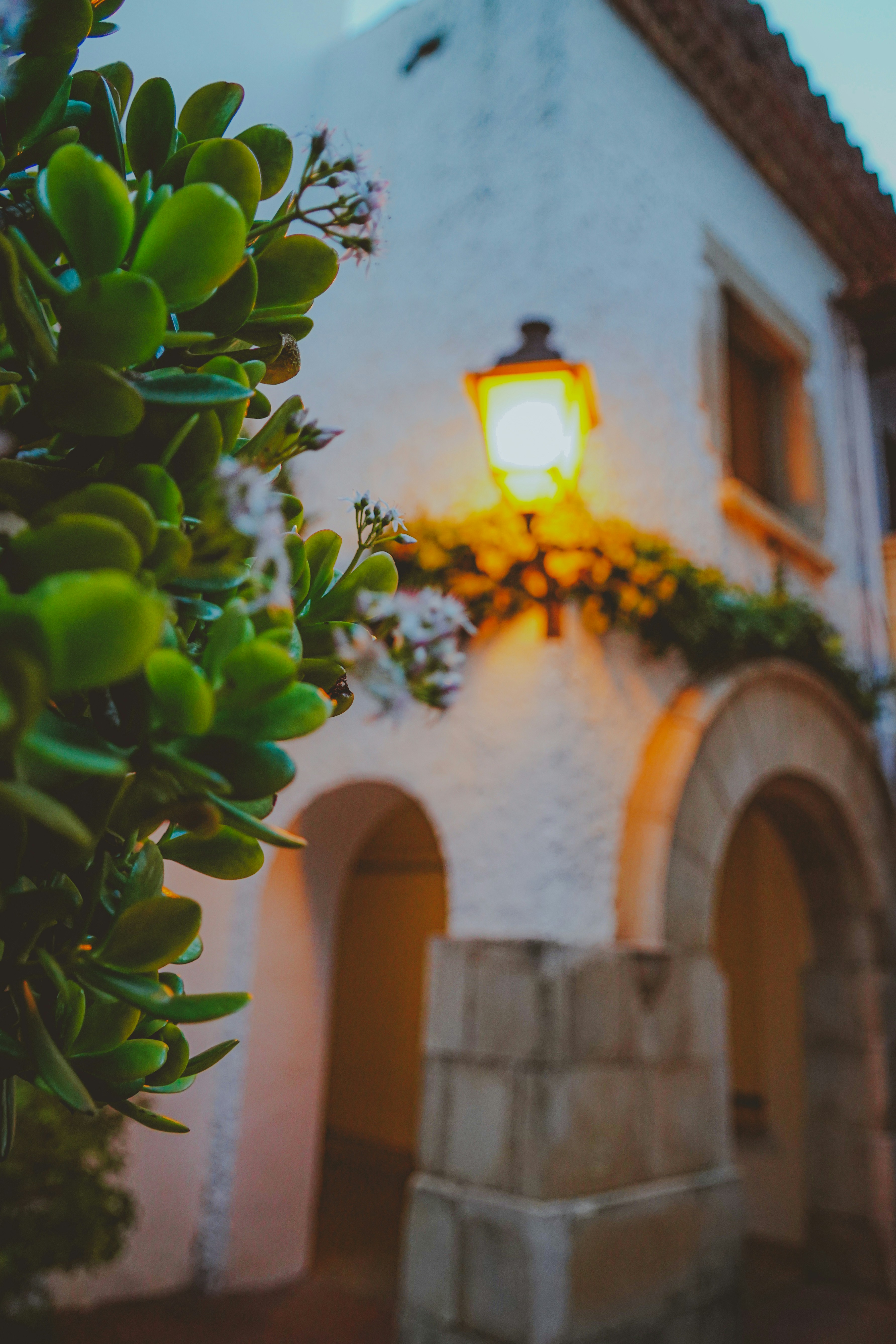 A street light sitting next to a white building photo – Free Street ...