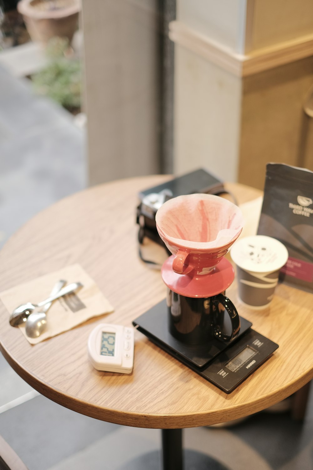 a wooden table topped with a coffee pot on top of a wooden table