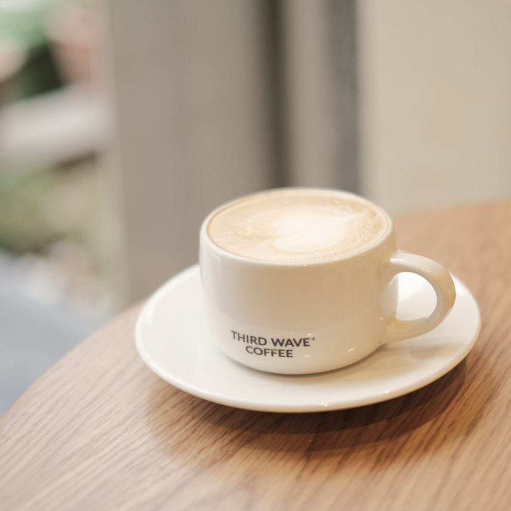uma xícara de café sentada em cima de um pires branco