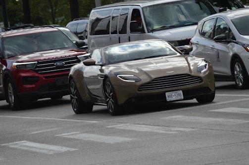 A sleek sedan driving along a city street on a sunny day.
