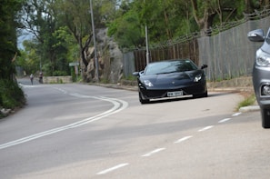 A sporty black sedan driving on a winding road.