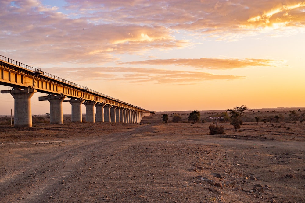 a bridge over a dirt road in the desert