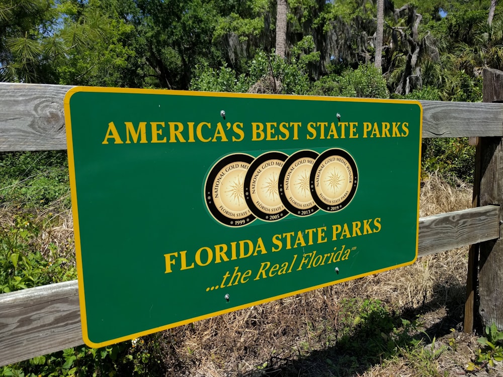 a sign for the florida state parks in front of a wooden fence