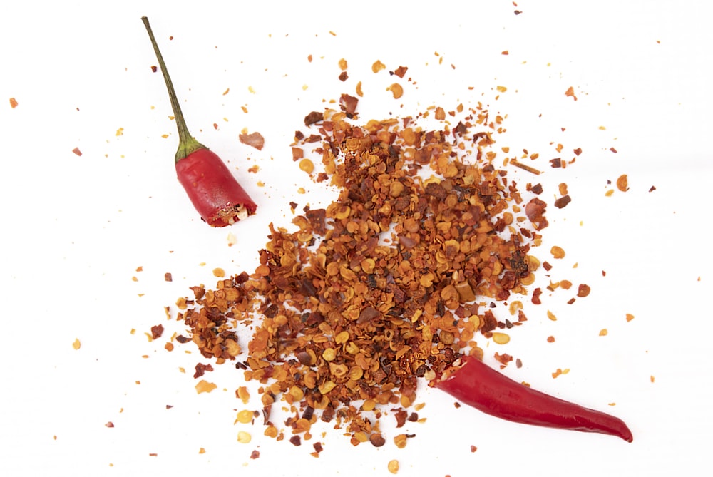a pile of spices next to a red chili pepper