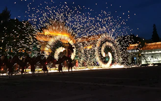 A vibrant night scene of a Pakistani wedding with glowing lanterns, golden stage lights, and colorful fireworks bursting in the sky.