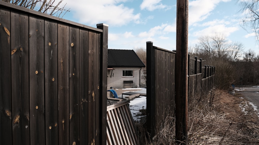 a wooden fence with a house in the background