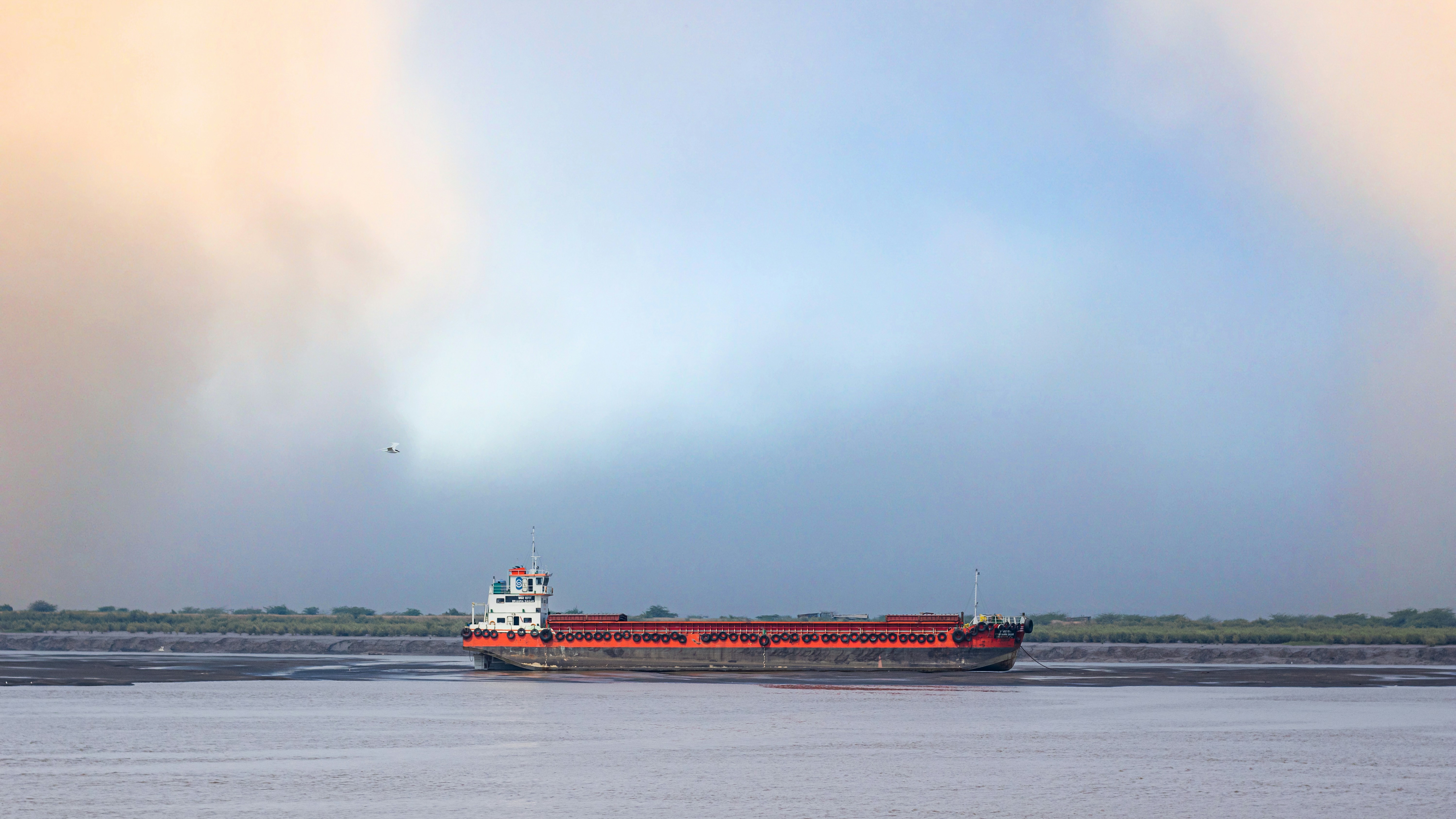 a large boat floating on top of a large body of water, Boat in the bank of river tapi