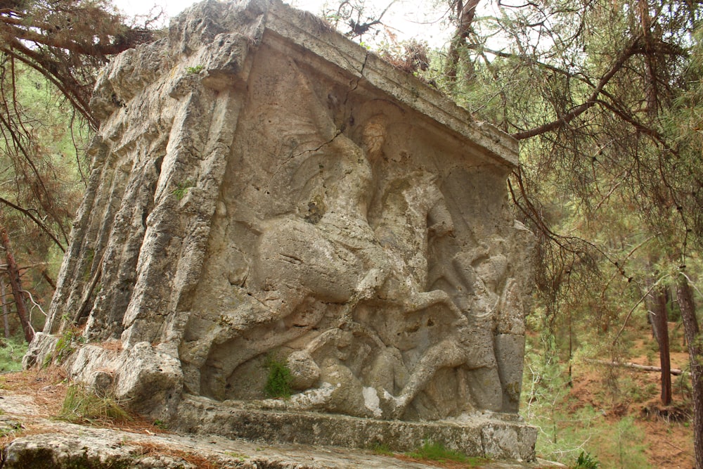 a statue of a man riding a horse in a forest