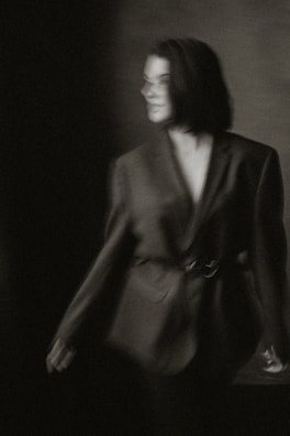 A moody black-and-white 35mm film photo capturing Apollo in a striking Westwood blazer against a gritty city backdrop.