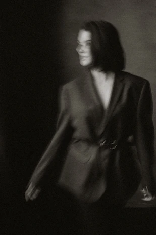 Moody black-and-white photo of a model wearing Rusbelsoon streetwear against an industrial backdrop.