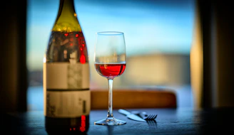 a glass of wine next to a bottle of wine
