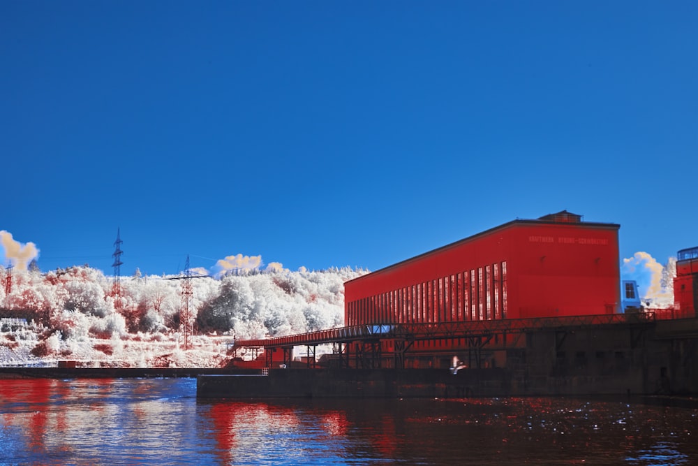 a red building sitting on the side of a river
