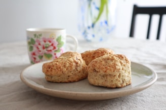 A freshly brewed cup of coffee paired with a homemade scone on a charming ceramic plate.