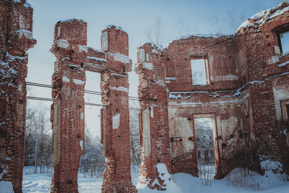地面に雪が積もった古いレンガ造りの建物