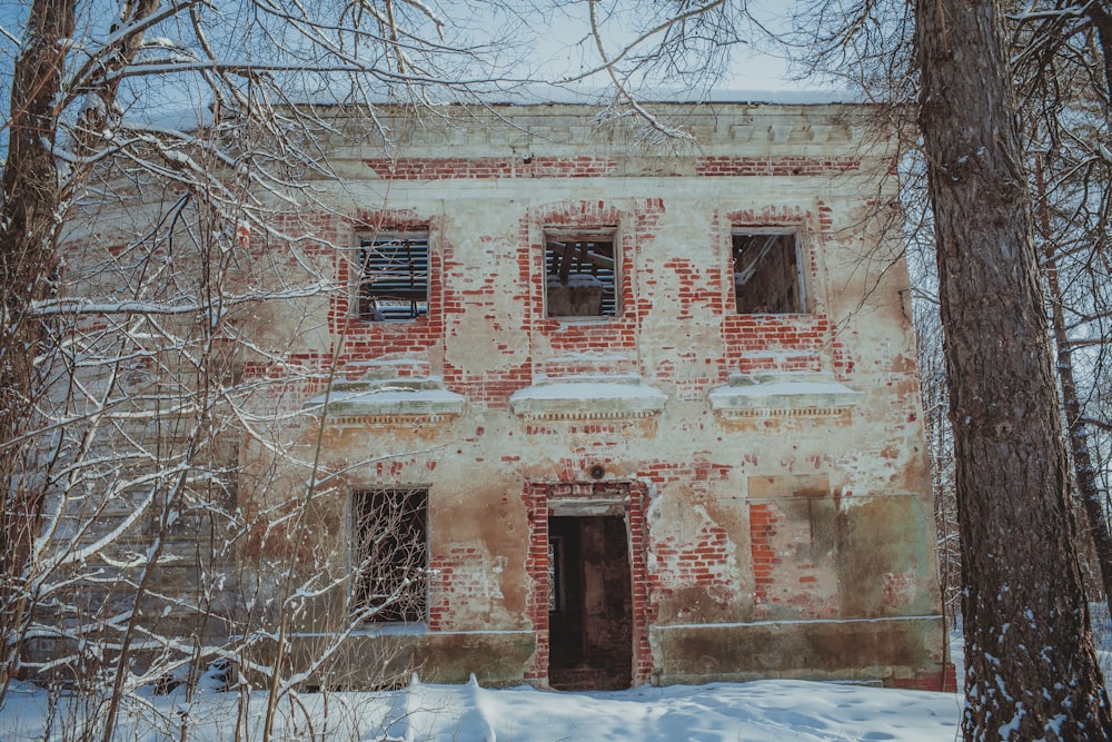 an old brick building surrounded by trees and snow