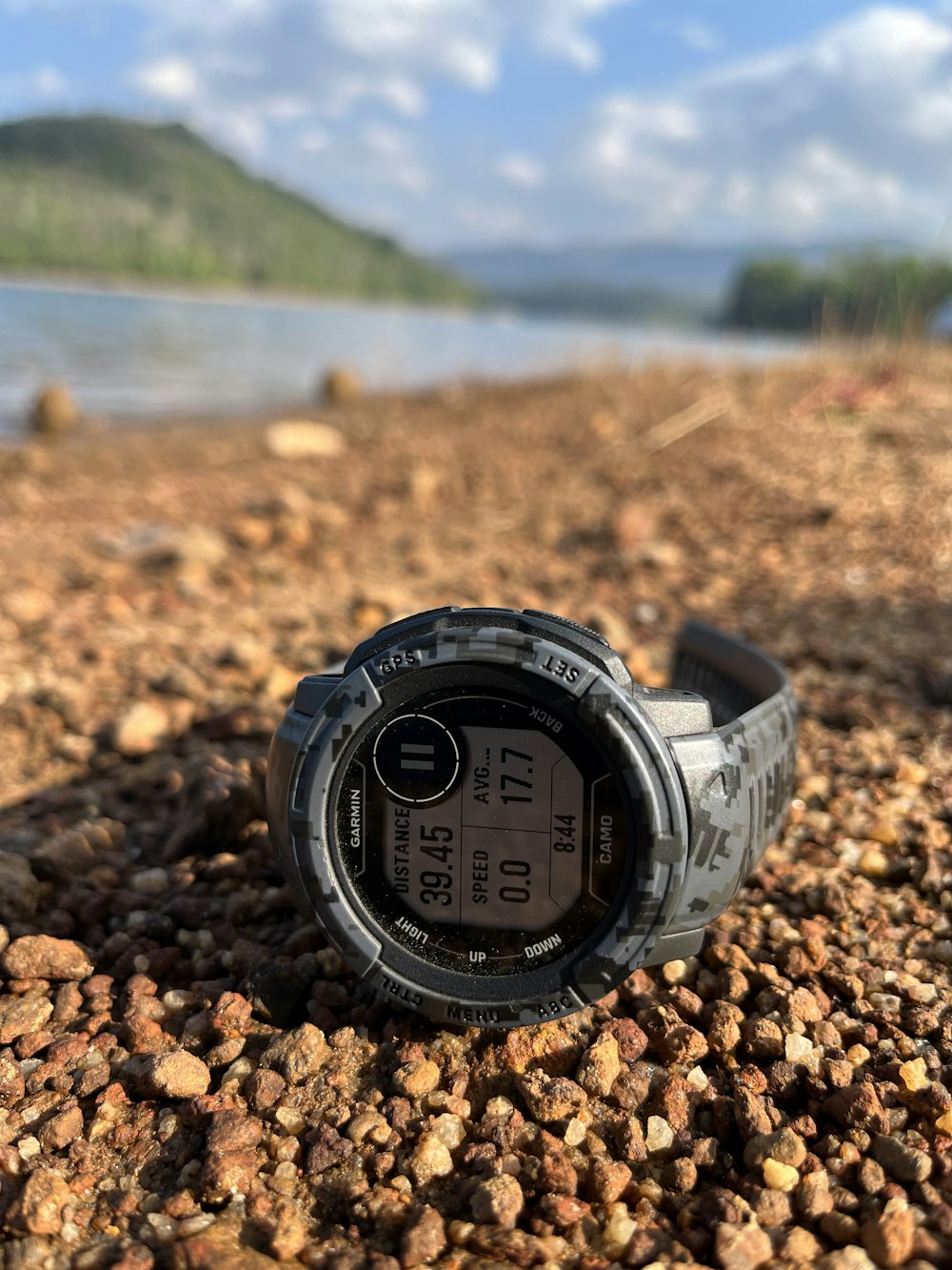a close up of a watch on a rocky beach