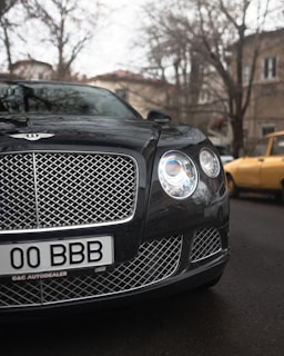 A close-up of a well-maintained luxury car parked in front of the Hannan Cars dealership.