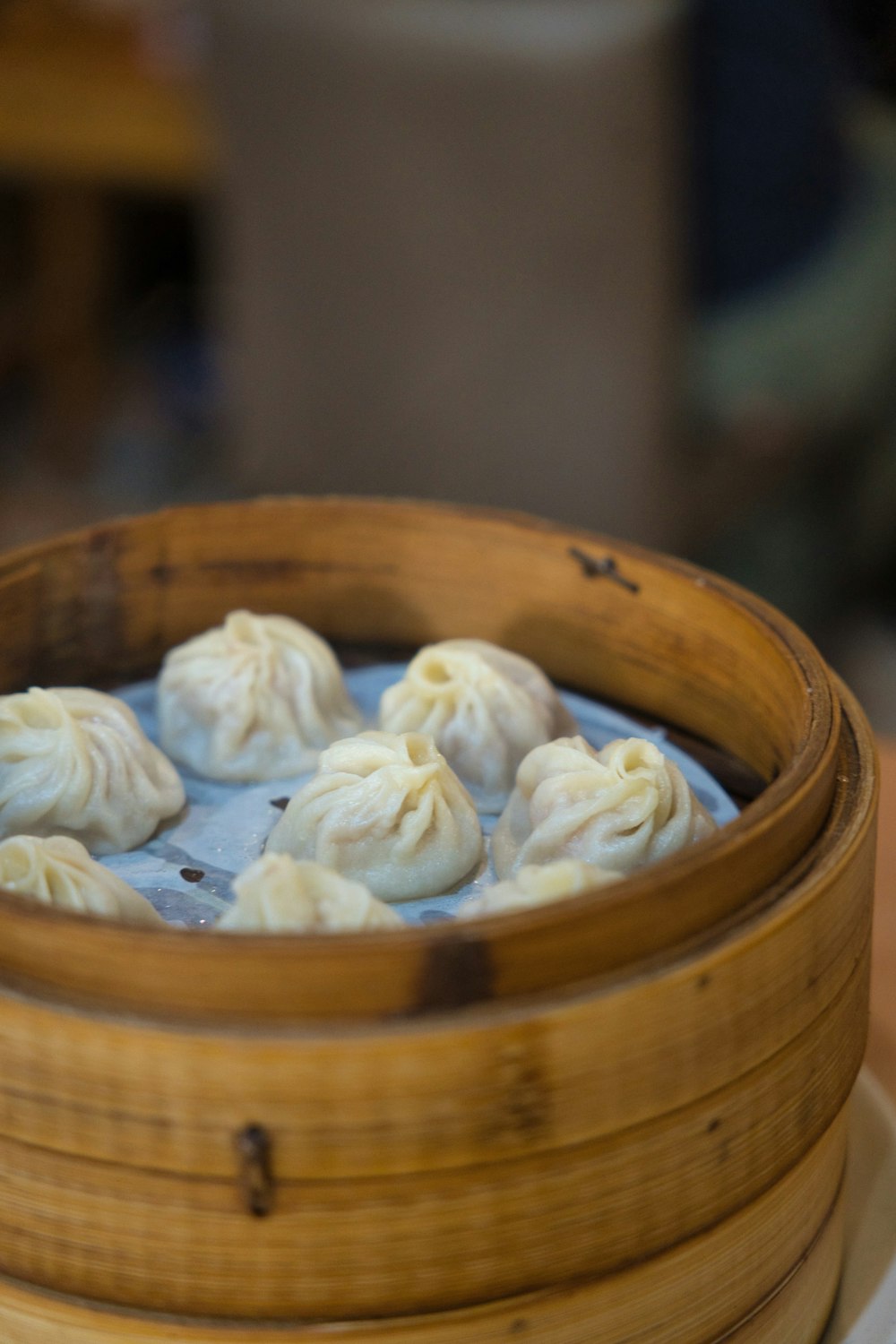a wooden container filled with dumplings on top of a table