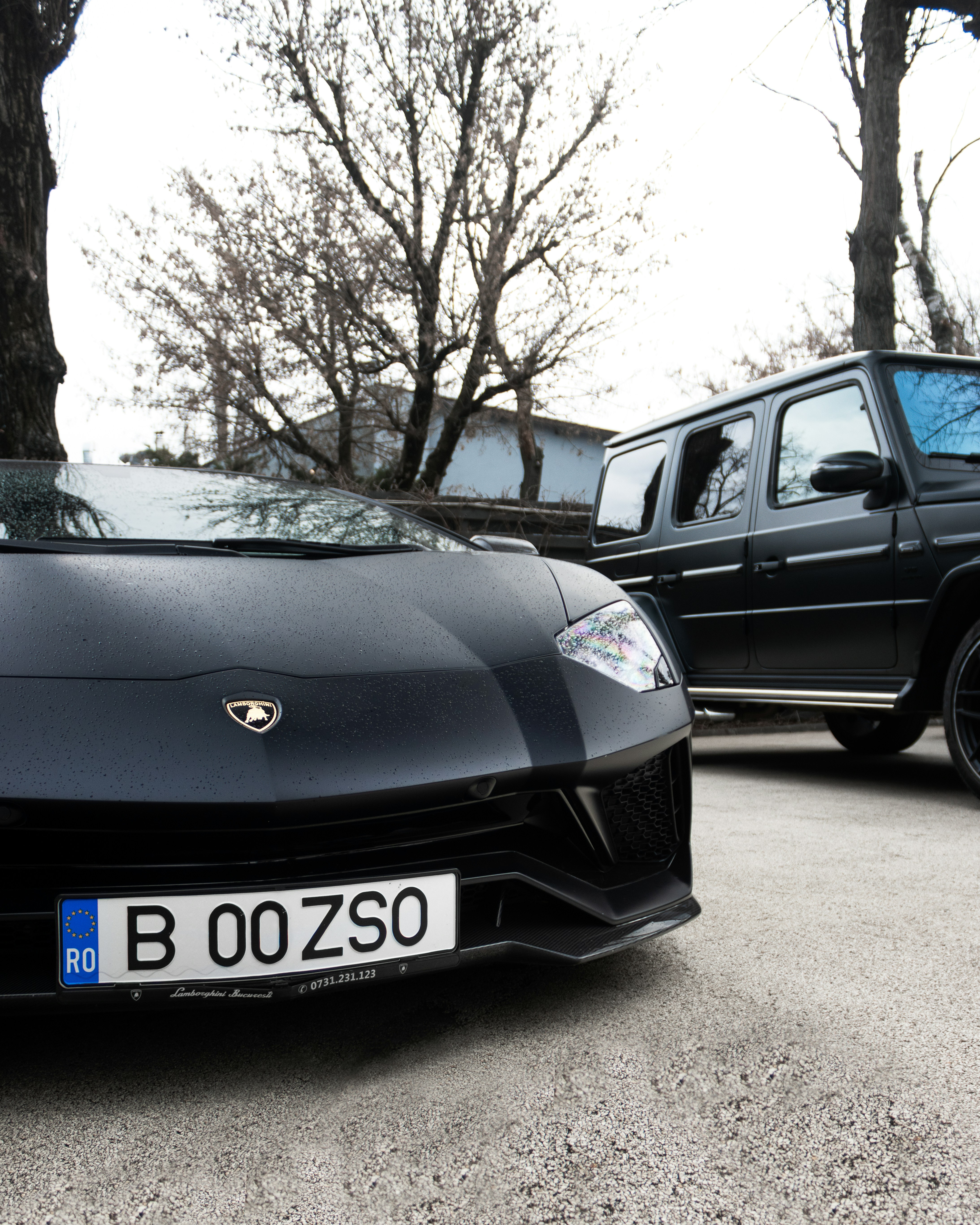 a black sports car parked next to a black truck
