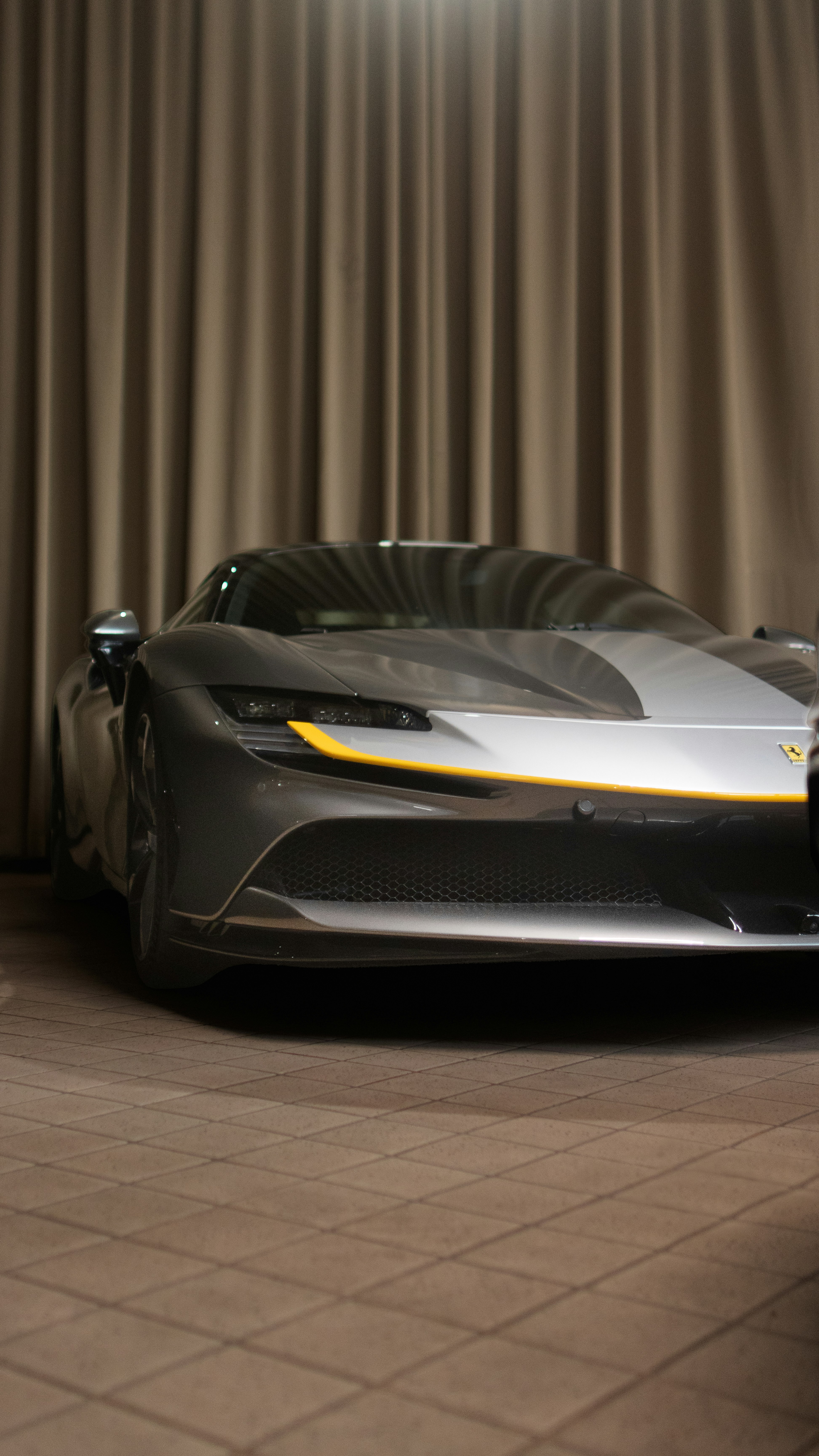 a silver sports car parked in front of a curtain
