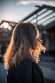 the back of a woman's head as she walks down the street
