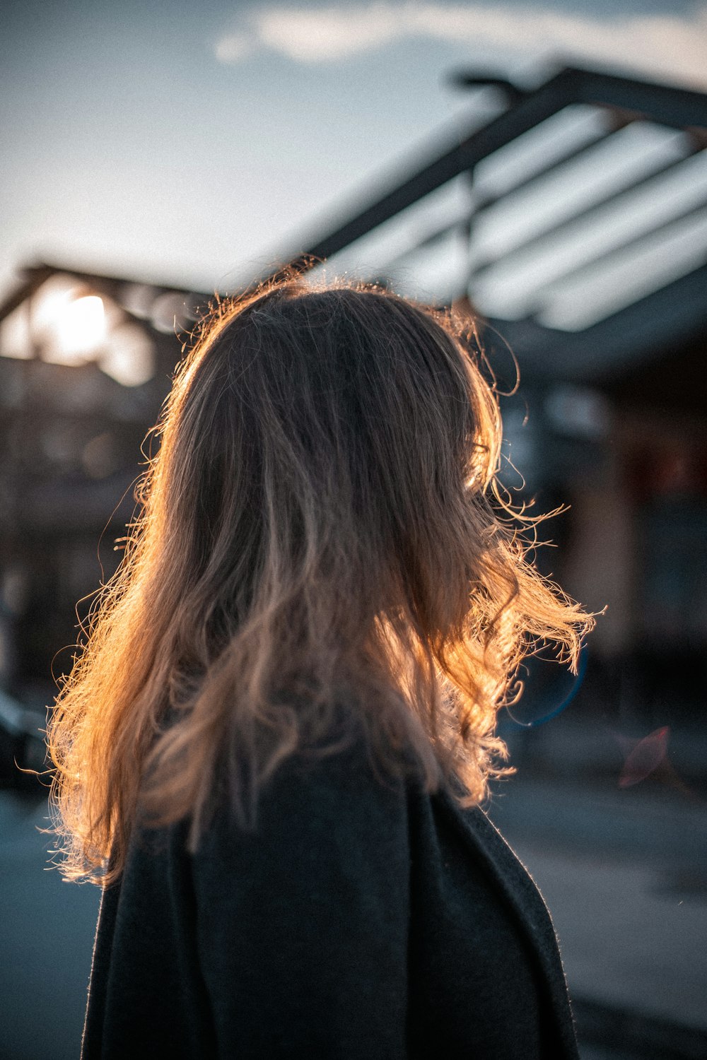 the back of a woman's head as she walks down the street