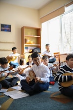 a group of children sitting on the floor playing instruments