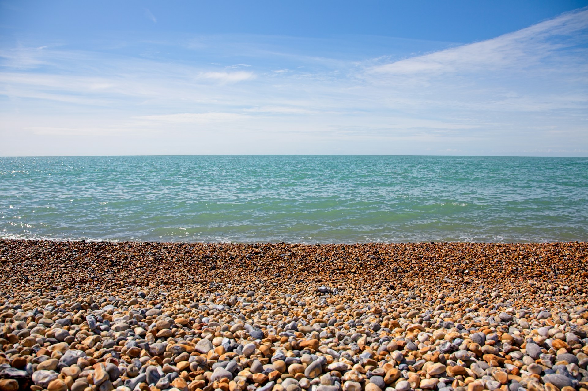 a rocky beach with a body of water in the background