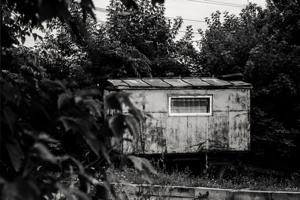 a black and white photo of an old outhouse