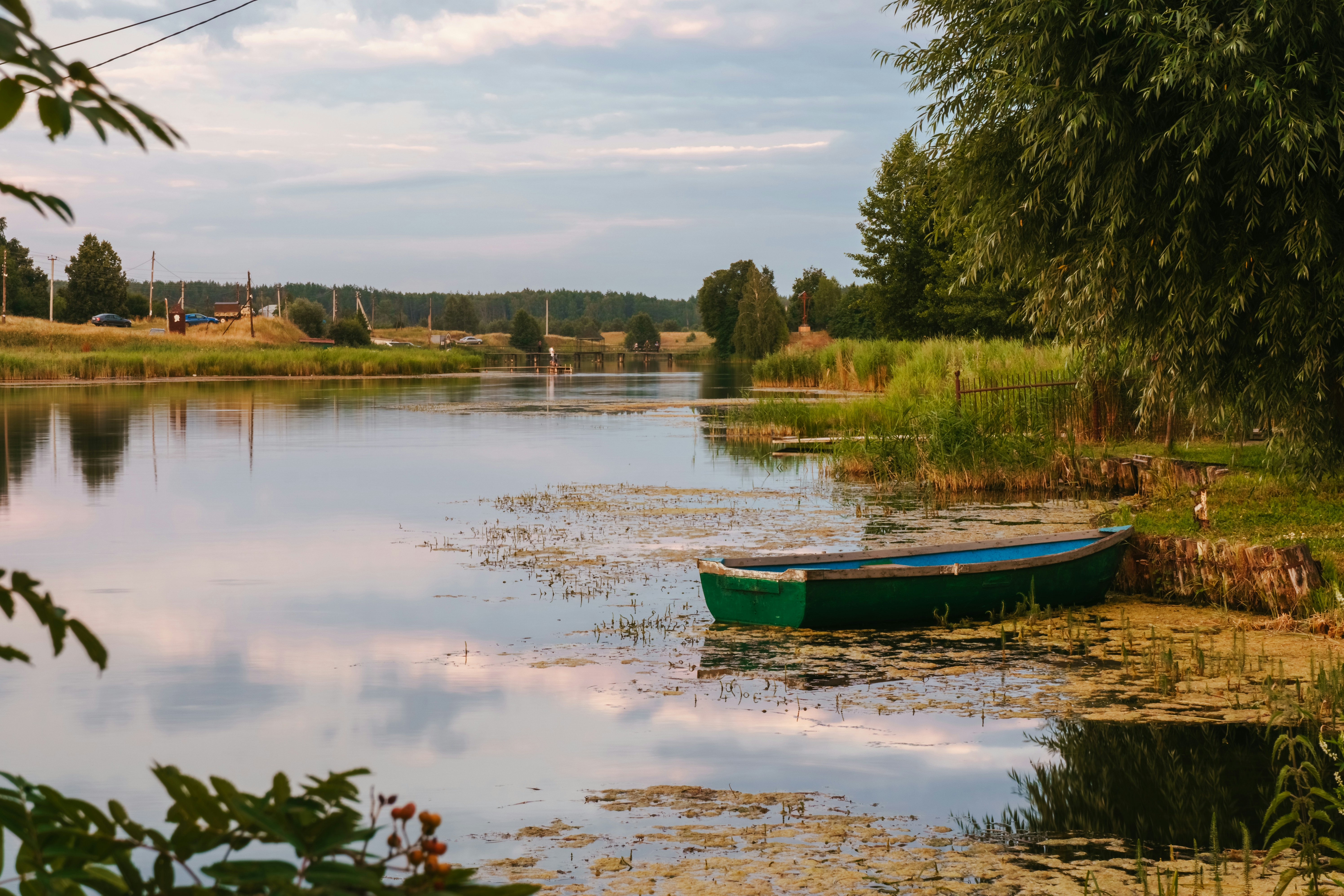 a small green boat sitting on top of a lake