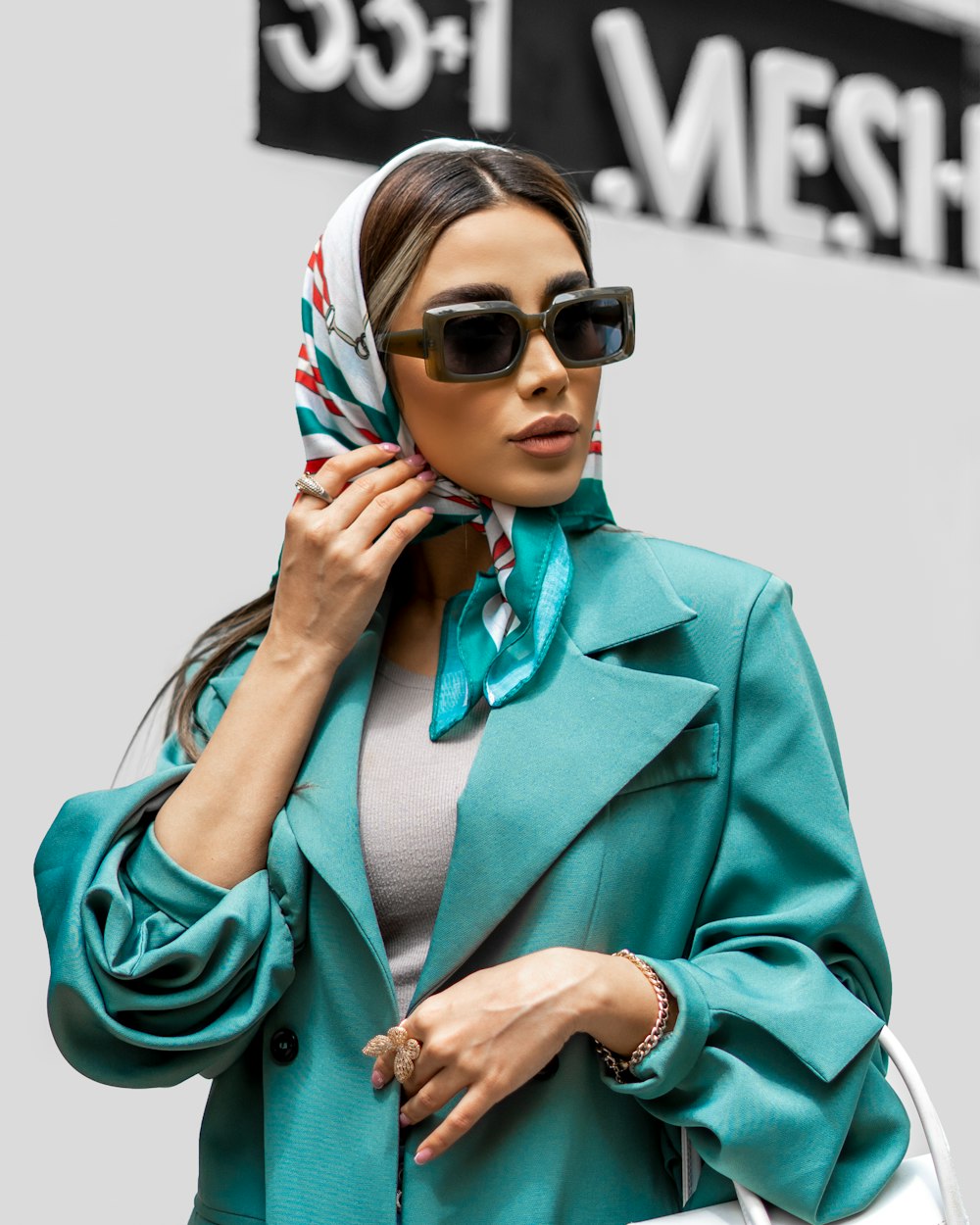 a woman wearing sunglasses and a green coat