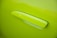 A close-up view of a vibrant lime green car door handle, seamlessly integrated into the door's surface.