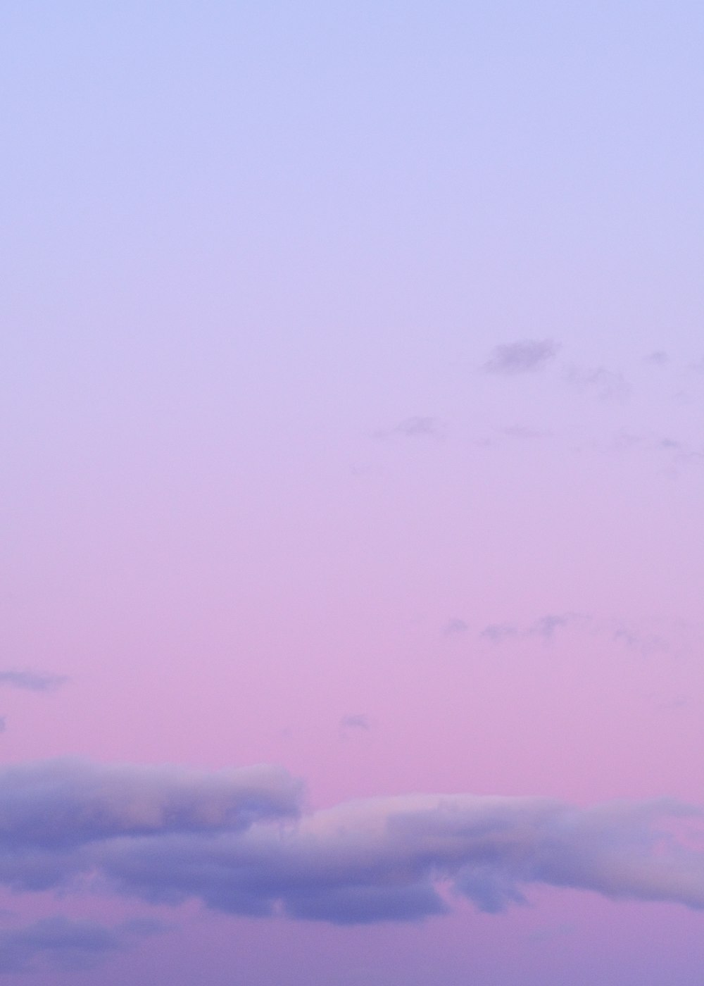 a plane flying in the sky at dusk