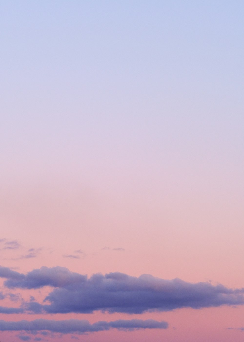 a plane flying in the sky at sunset