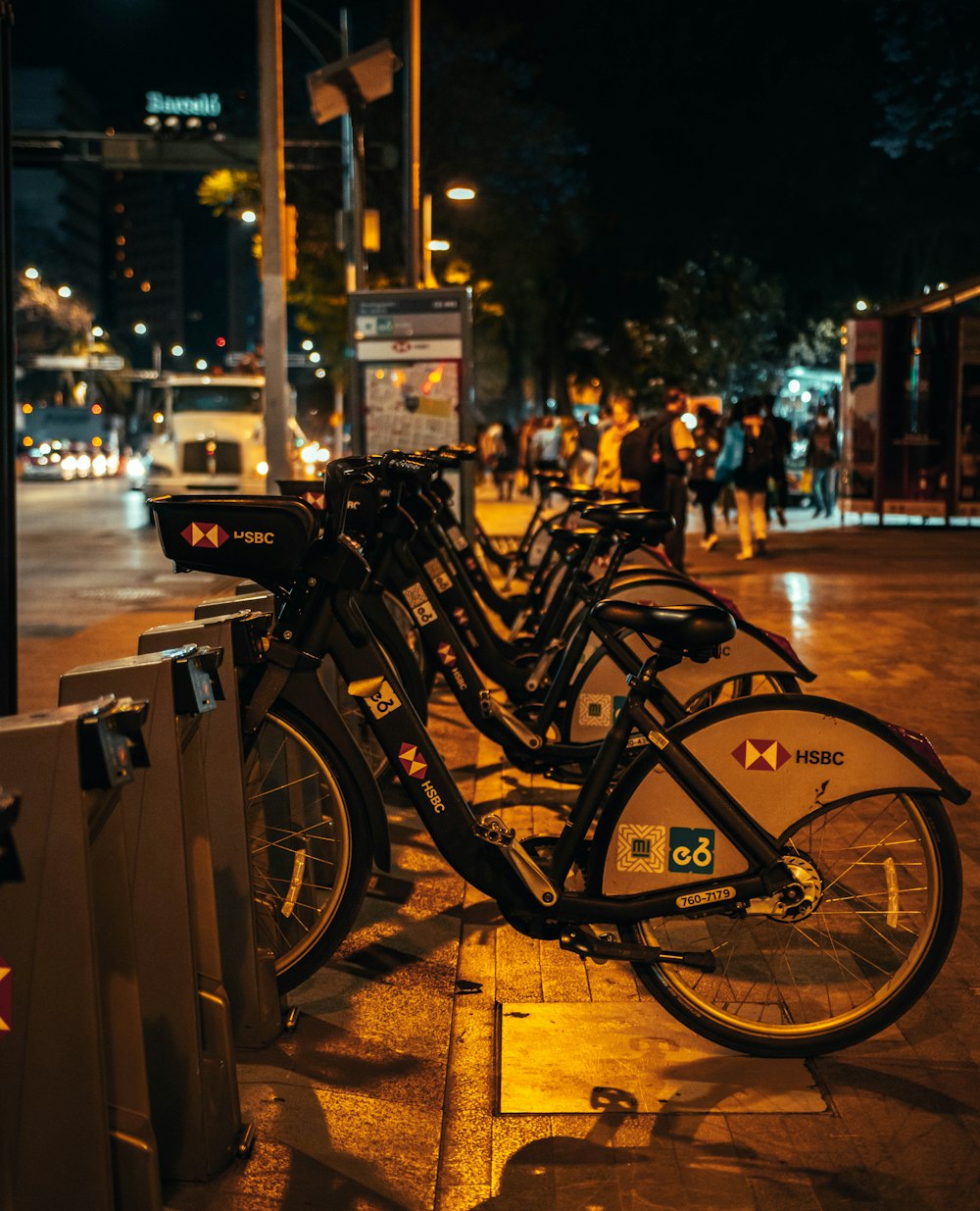 uma fileira de bicicletas estacionadas uma ao lado da outra em uma calçada