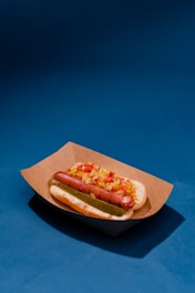 Close-up of a classic hot dog with mustard and ketchup on a black and white checkered paper.