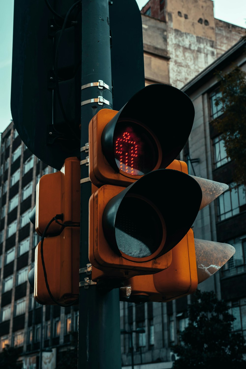 a traffic light on a pole with a building in the background