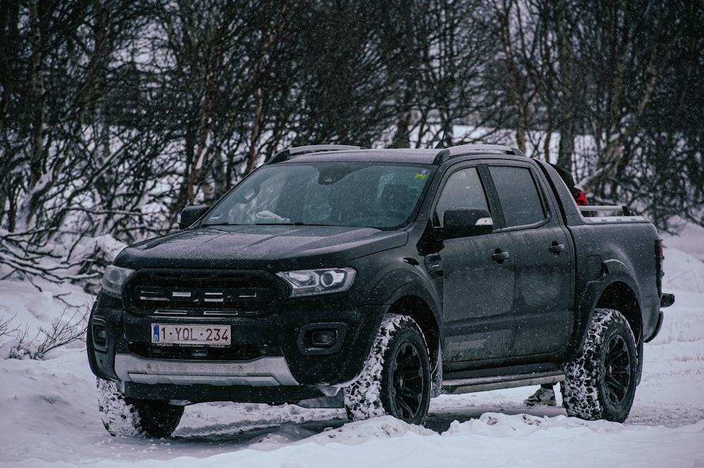 a black truck is parked in the snow